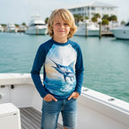 Tween dude on a boat in Destin Marina wearing a long-sleeve sun rashie with a large graphic print of a marlin jumping out of the ocean.