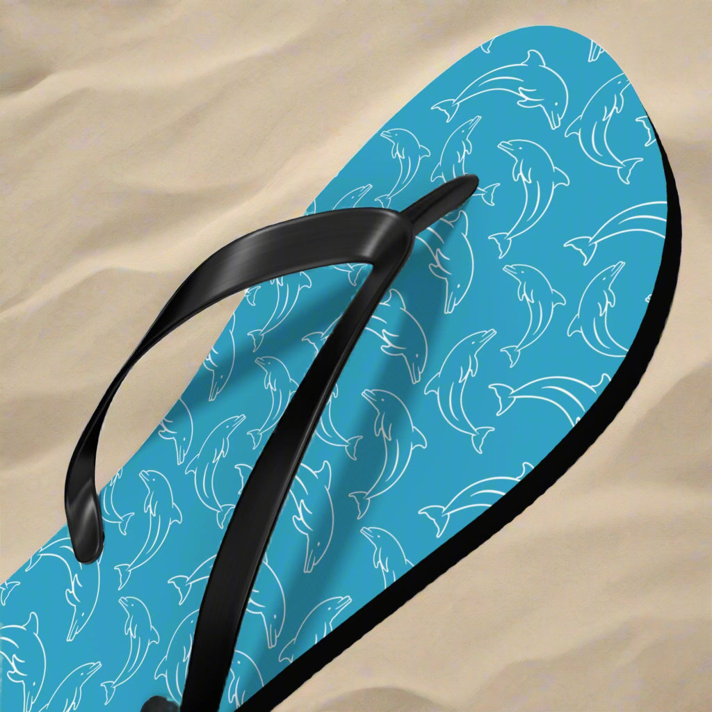 Blue flip-flop with dolphin pattern on a beach background