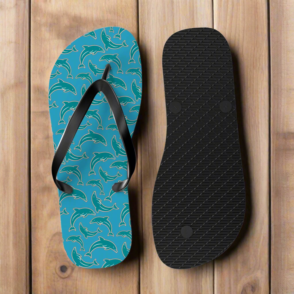 Turquoise flip-flop with dolphin pattern and black sole on a rustic nautical wood background