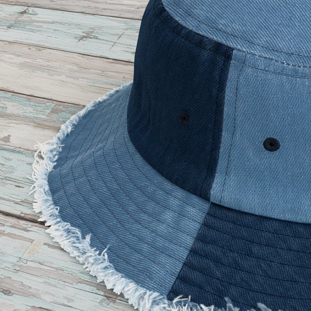 Close-up of a blue denim bucket hat with frayed edge on a nautical wood surface