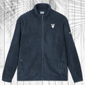 A dark gray fleece zip-up jacket with a stand collar, shown flat against a white wood plank background with a palm leaf pattern overlay. The jacket features a small white shark tooth embroidered on the left chest and a small white Columbia logo on the right sleeve.