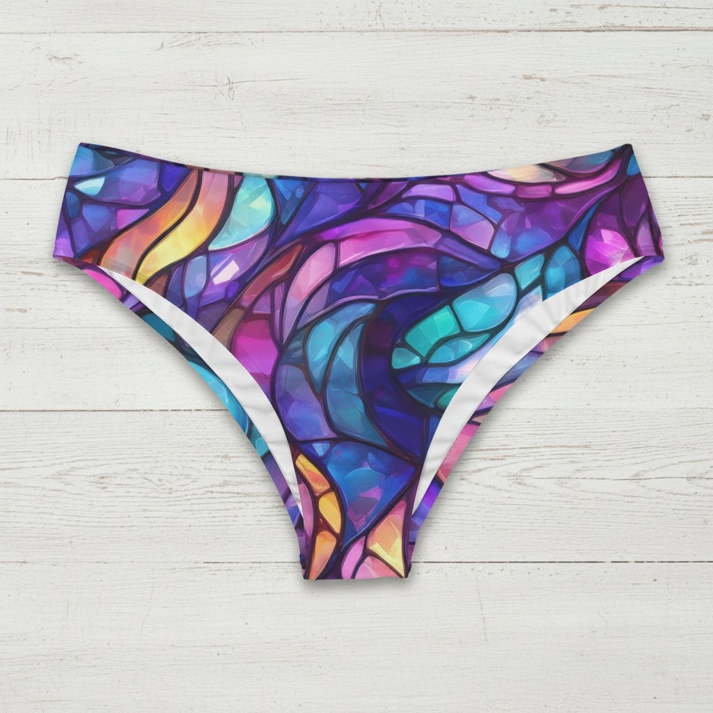 Colorful stained glass patterned bikini bottoms on a rustic wood background