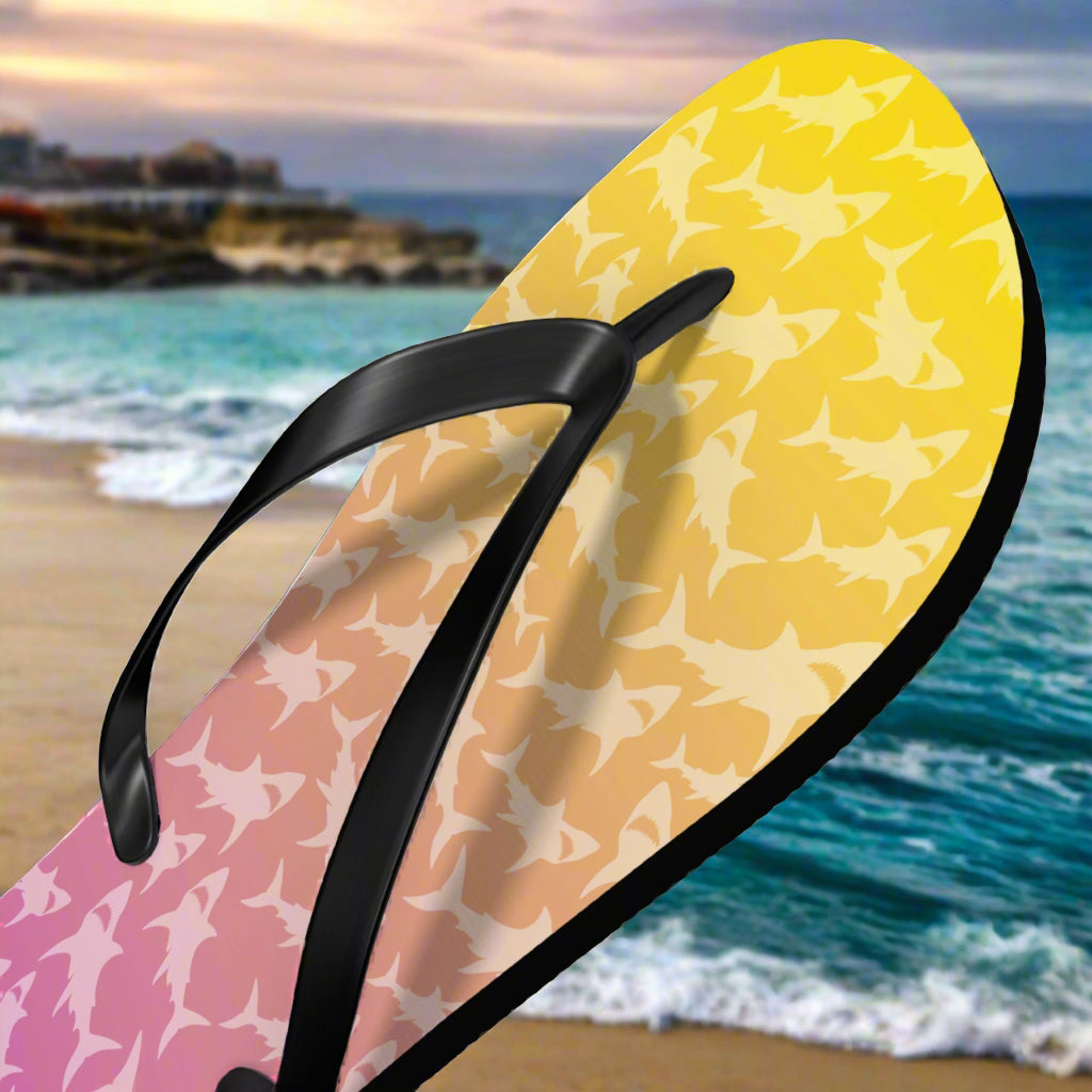 Flip-flop with shark pattern on a beach background