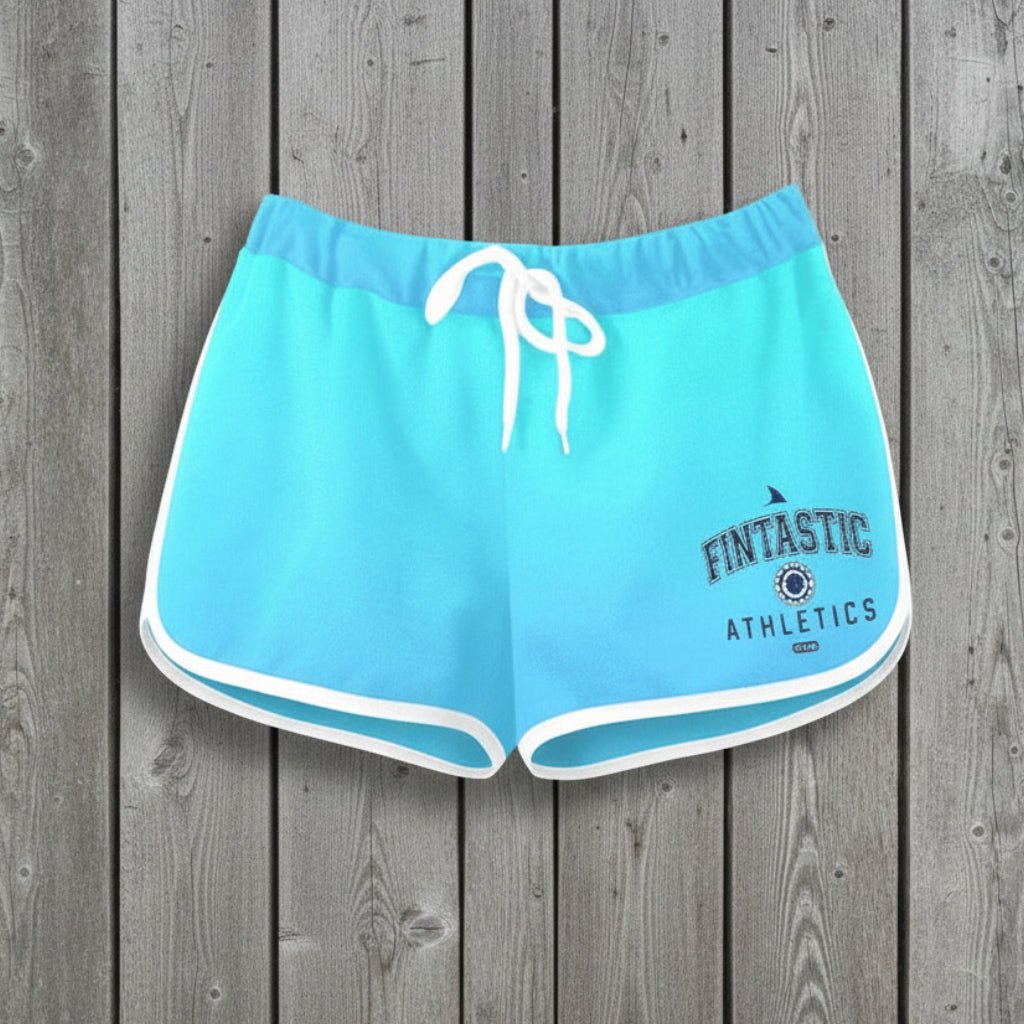 Light blue athletic shorts with a Fintastic Athletics logo on a rustic wood background