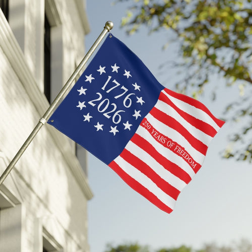 Flag with '1776-2026' and '250 Years of Freedom' text against a clear sky.