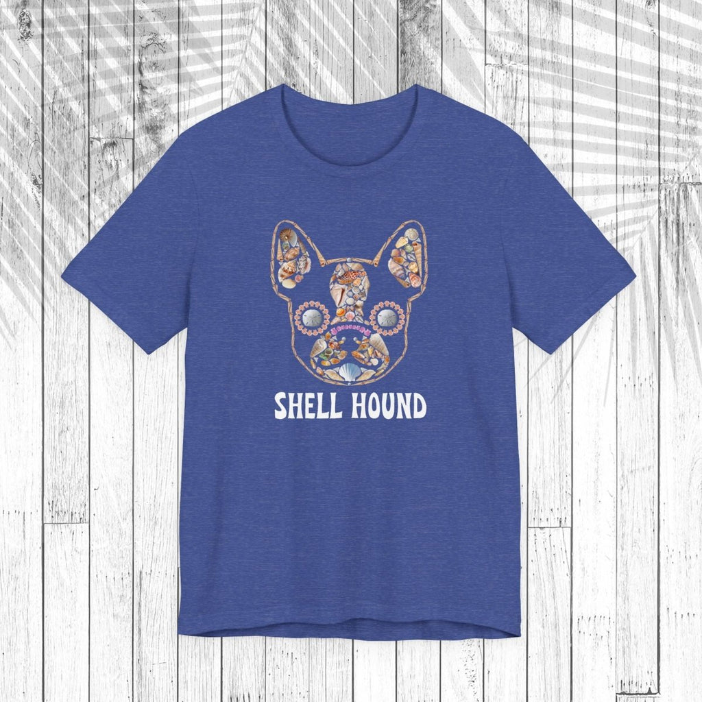 A heather blue short-sleeve t-shirt featuring a colorful seashell graphic of a French Bulldog with the text 'SHELL HOUND' printed below it, displayed flat against a white wood plank background.