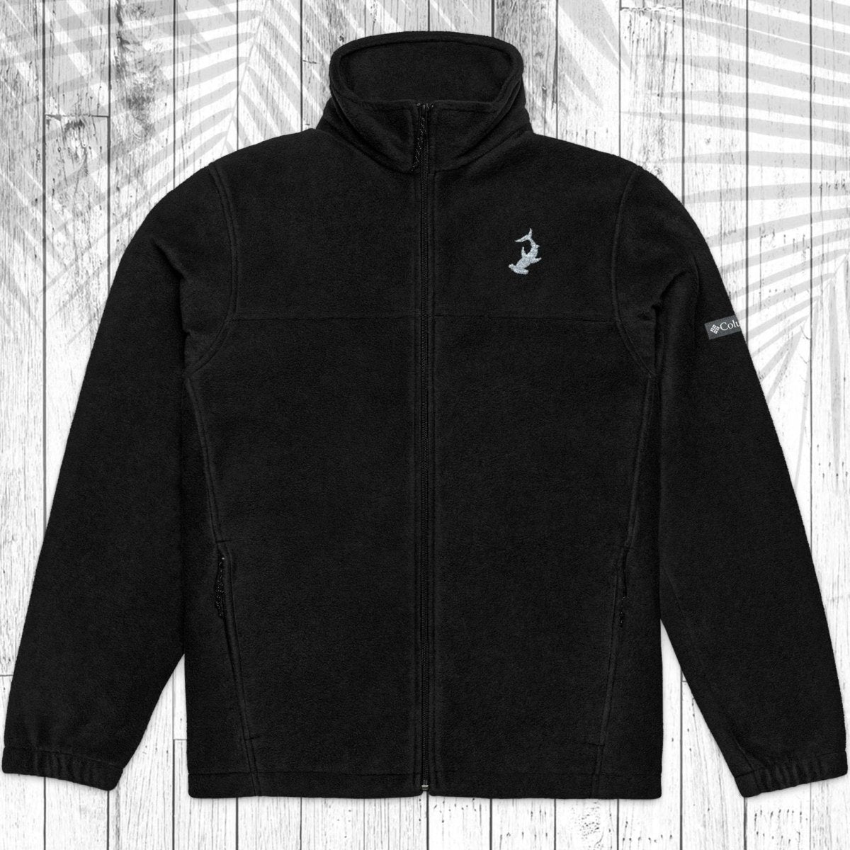 A black fleece zip-up jacket with a stand-up collar, laid flat against a white wood plank background with a faint palm leaf pattern.