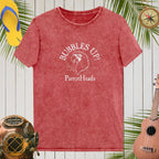 Red t-shirt with 'Bubbles Up! ParrotHeads' design on a wooden background with tropical elements.