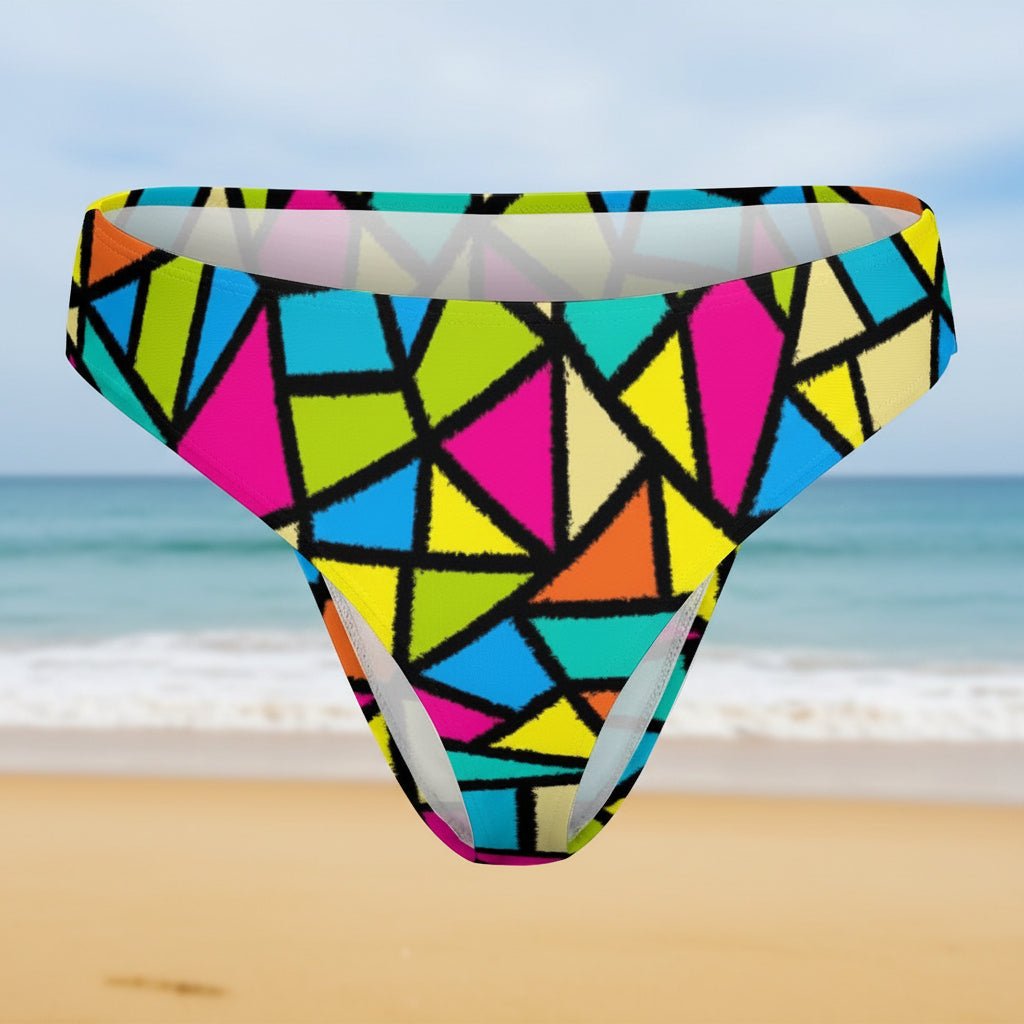 Colorful geometric patterned swim brief on a faded beach background