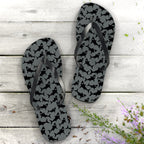 Flip-flops with black pattern on gray nautical wood background