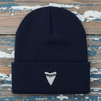 A dark navy blue ribbed knit beanie hat with a folded cuff, featuring a white embroidered shark tooth logo centered on the cuff.