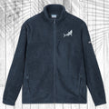 A dark gray fleece zip-up jacket with a stand collar, shown flat against a white wood plank background with a palm leaf pattern overlay. The jacket features a Great White Shark embroidered on the left chest and a small white logo on the right sleeve.