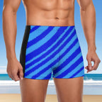 Blue and black striped swim shorts worn by a person with a beach background