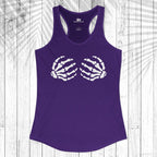 A purple racerback tank top with a white skeleton hand graphic on the chest, displayed flat against a white wood plank background with a palm leaf overlay.