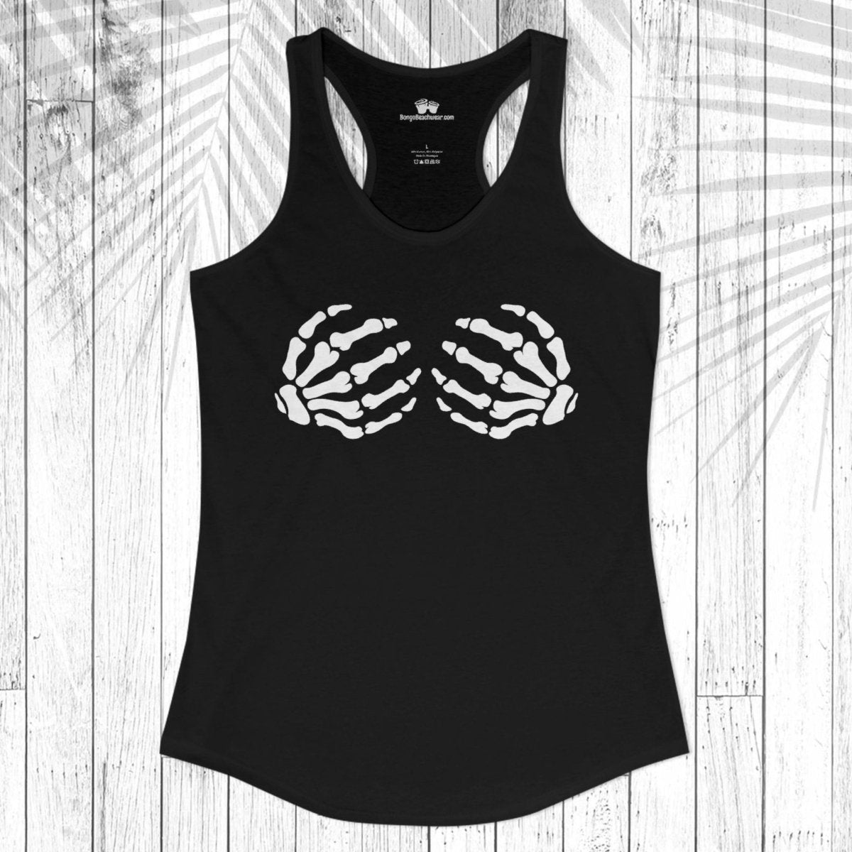 A black racerback tank top with a white skeletal hand graphic printed on the chest, laid flat on a white wood plank background with a palm leaf shadow overlay.