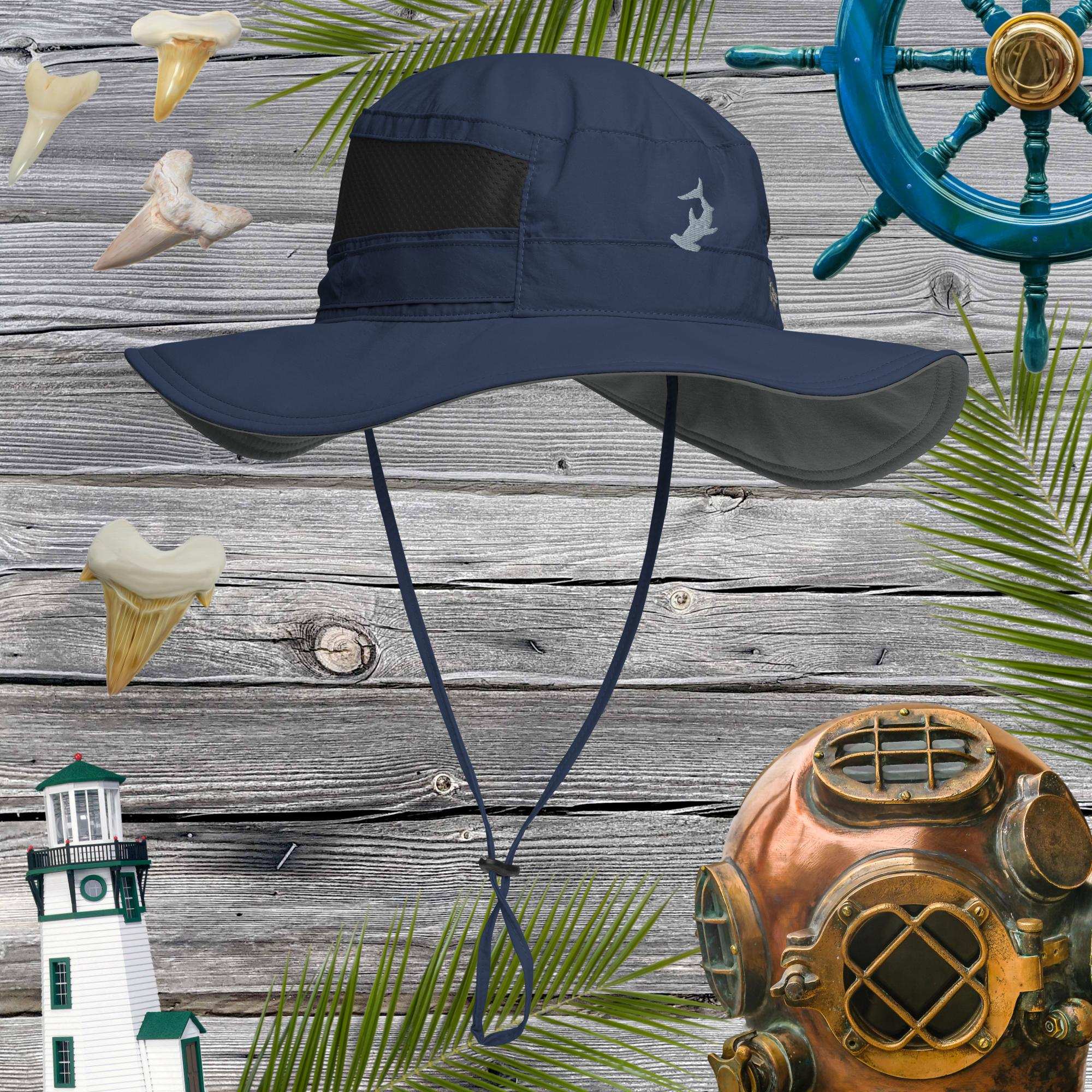 Navy bucket hat with hammerhead shark embroidery on a wooden background with ship wheel, lighthouse, and diving helmet.