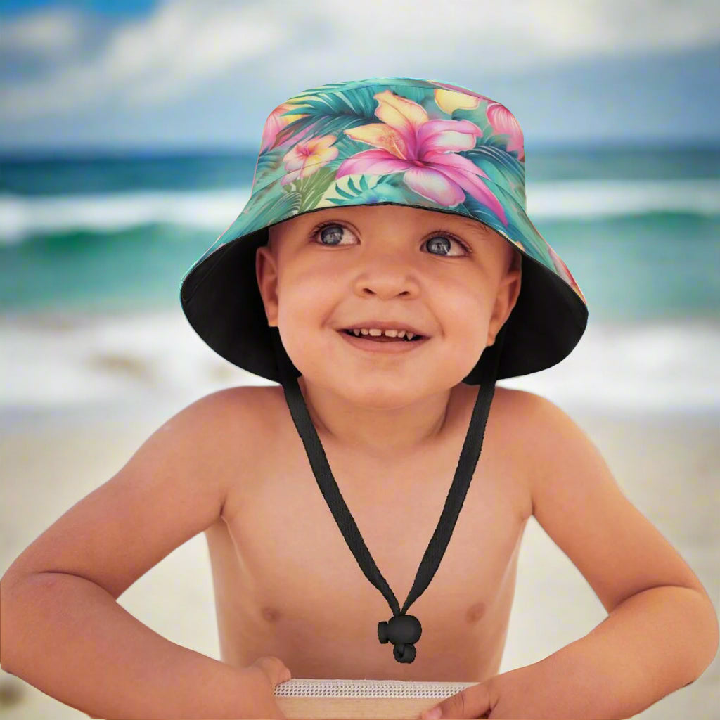 Child wearing a colorful floral bucket hat with a beach background