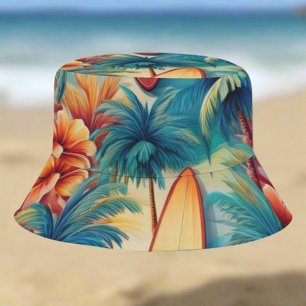 Colorful bucket hat with tropical design featuring palm trees and flowers sitting on a beach in Hawaii