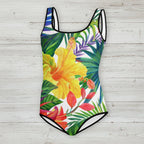 One-piece swimsuit with tropical floral design on a rustic wood background