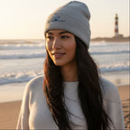 A light gray heather knit cuffed beanie hat featuring an embroidered graphic of a small gray Frenchton standing on a surfboard on the front cuff.
