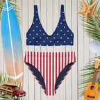 Americana-themed swimsuit with star and stripe pattern on a wooden background with beach accessories.