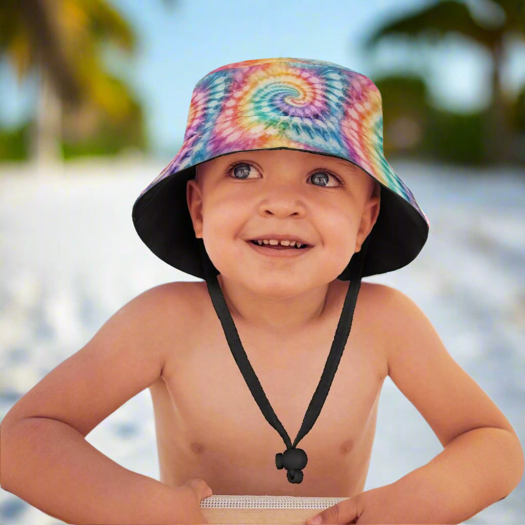 Child wearing a colorful tie-dye bucket hat on a beach in Naples Florida