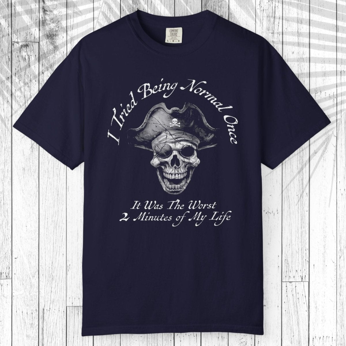 A navy blue short-sleeve t-shirt with a colorful graphic of an open shark mouth on the chest, displayed flat against a white wood plank background.