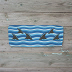 Bandeau top with shark design on a blue and white striped background on rustic nautical wood.
