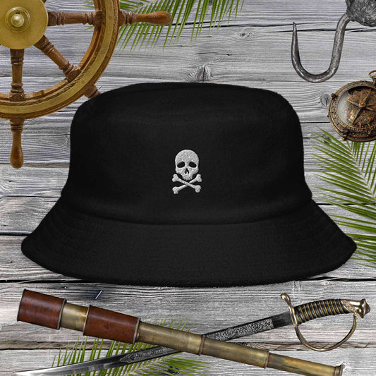 Jolly Pirate Flag Bucket Hat made of unstructured terry cloth with skull design on a wooden background.