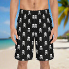 Men's Board Shorts with skull and crossbones in a polka-dot pattern worn by a surfer dude standing on and island beach