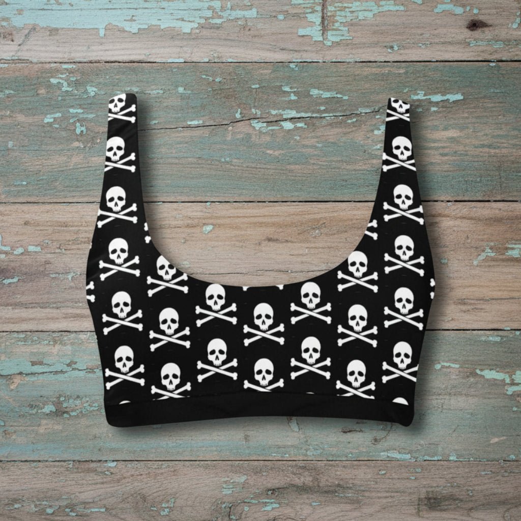 Black crop top with skull and crossbones pattern on a rustic wood background