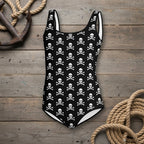 Black swimsuit with white skull and crossbones pattern on a rustic wood nautical background
