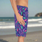 Guy wearing junonia board shorts standing on a beach with his thumb in his pocket