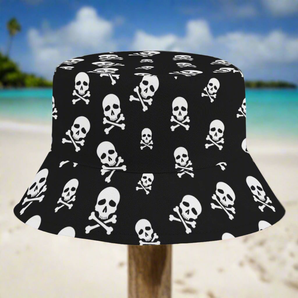 Black bucket hat with white skull and crossbones pattern sitting on a post in a Caribbean island beach