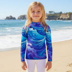 Child wearing a blue and purple wave-patterned long-sleeve shirt on a La Jolla Beach