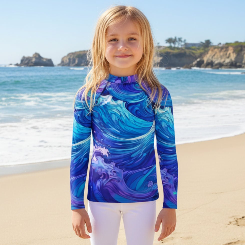 Child wearing a blue and purple wave-patterned long-sleeve shirt on a La Jolla Beach