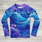Long-sleeve kids rash guard with blue and purple wave pattern on a rustic wood background