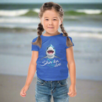 Cute Kid wearing a blue t-shirt with a shark graphic and 'Sharka' life' text hanging out on Daytona Beach