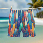 Colorful board shorts with surfboard design hanging on a clothesline in tropical island surfers' paradise