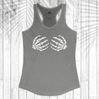 A gray racerback tank top with a white graphic of two skeletal hands on the chest, displayed flat against a white wood plank background with a palm leaf shadow overlay.