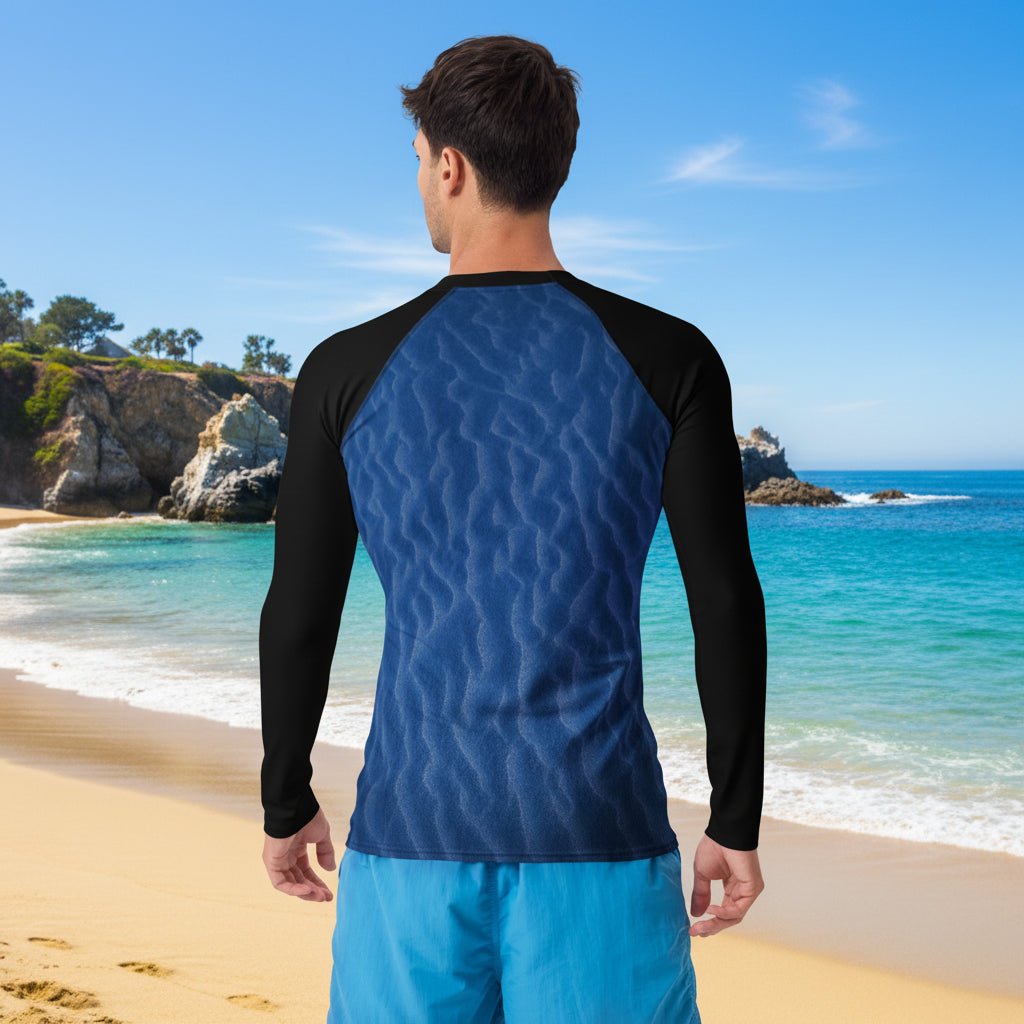 Man wearing a blue and black long-sleeve sun rashie on Laguna beach with ocean view