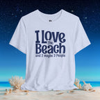 A light heather gray graphic t-shirt with the text 'I Love The Beach and 2 maybe 3 People' in navy blue, displayed on a beach scene background with sand, shells, and a starry night sky.