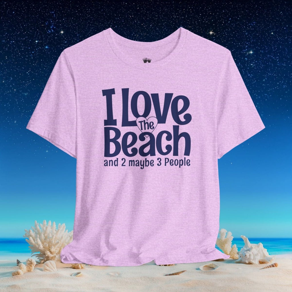 A light purple heather t-shirt with the text 'I Love The Beach and 2 maybe 3 People' in navy blue, displayed on a beach background with sand, shells, and a starry night sky.