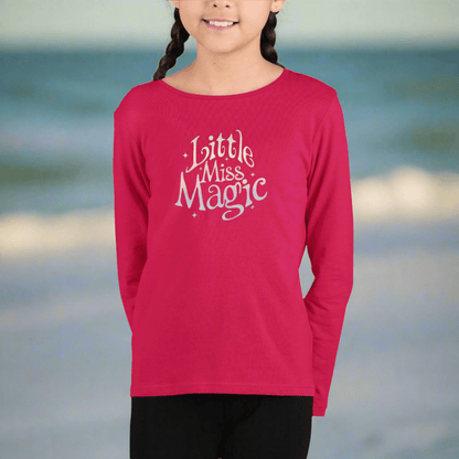Girl wearing a red long-sleeve shirt with 'Little Miss Magic' text on the beach in St. Pete 