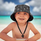 Child wearing a black bucket hat with skull pattern on a Caribbean island beach