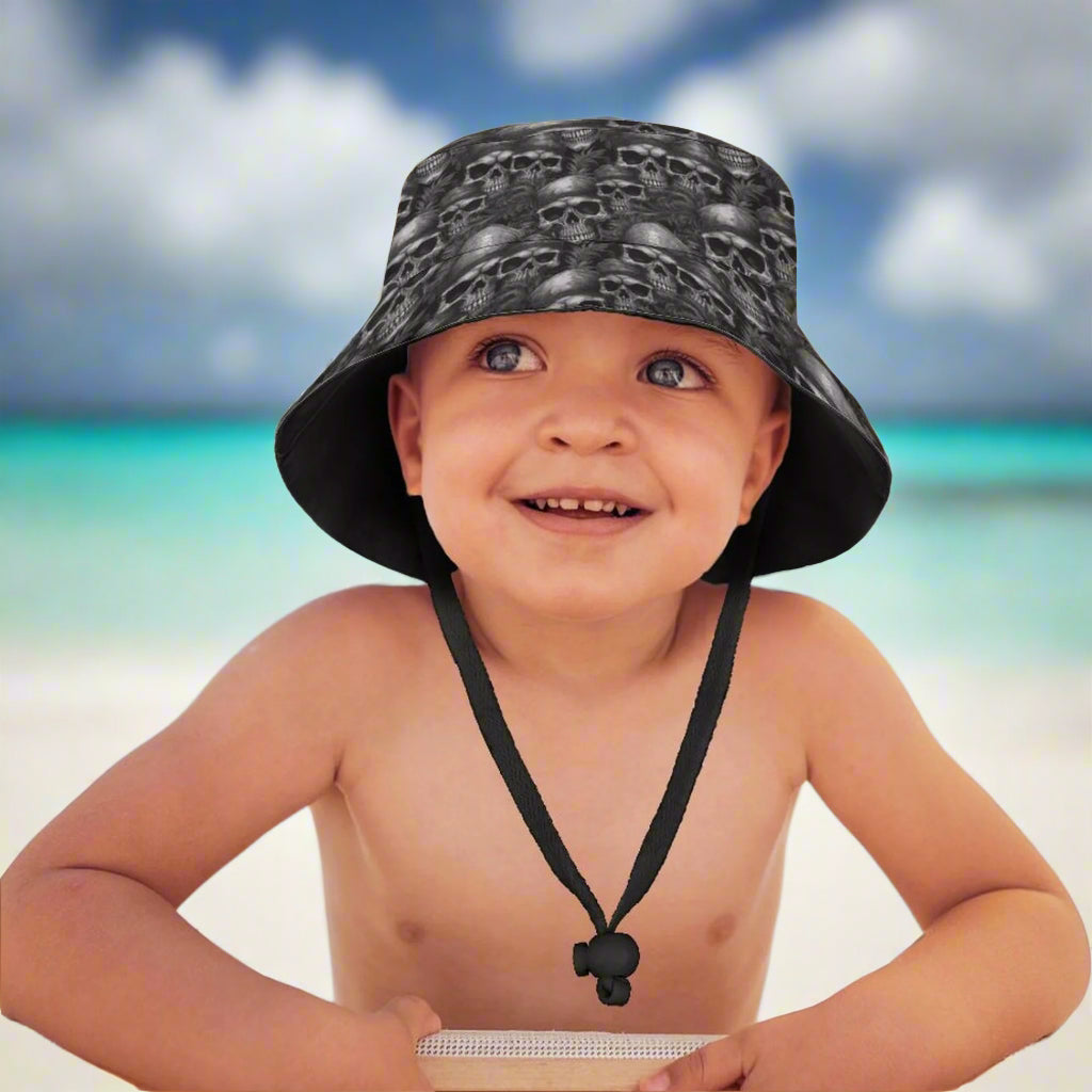 Child wearing a black bucket hat with skull pattern on a Caribbean island beach
