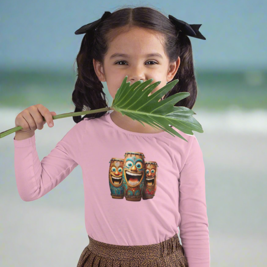 Young girl wearing a pink shirt with a laughing tiki bongos design, holding a plant leaf, having fun on Daytona Beach