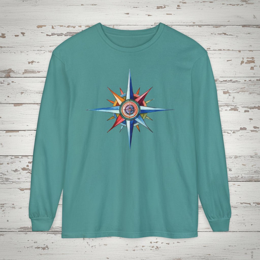 Teal long-sleeve shirt with a colorful compass design on a wooden background