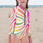 Child wearing a colorful swimsuit with a beach background