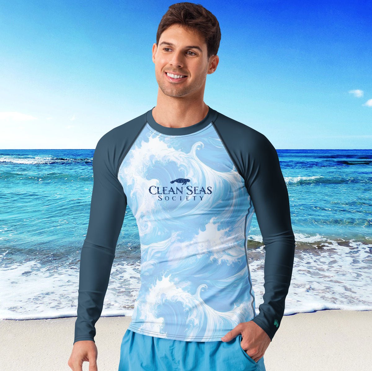 Man wearing a 'Clean Seas Society' shirt with ocean design on a beach